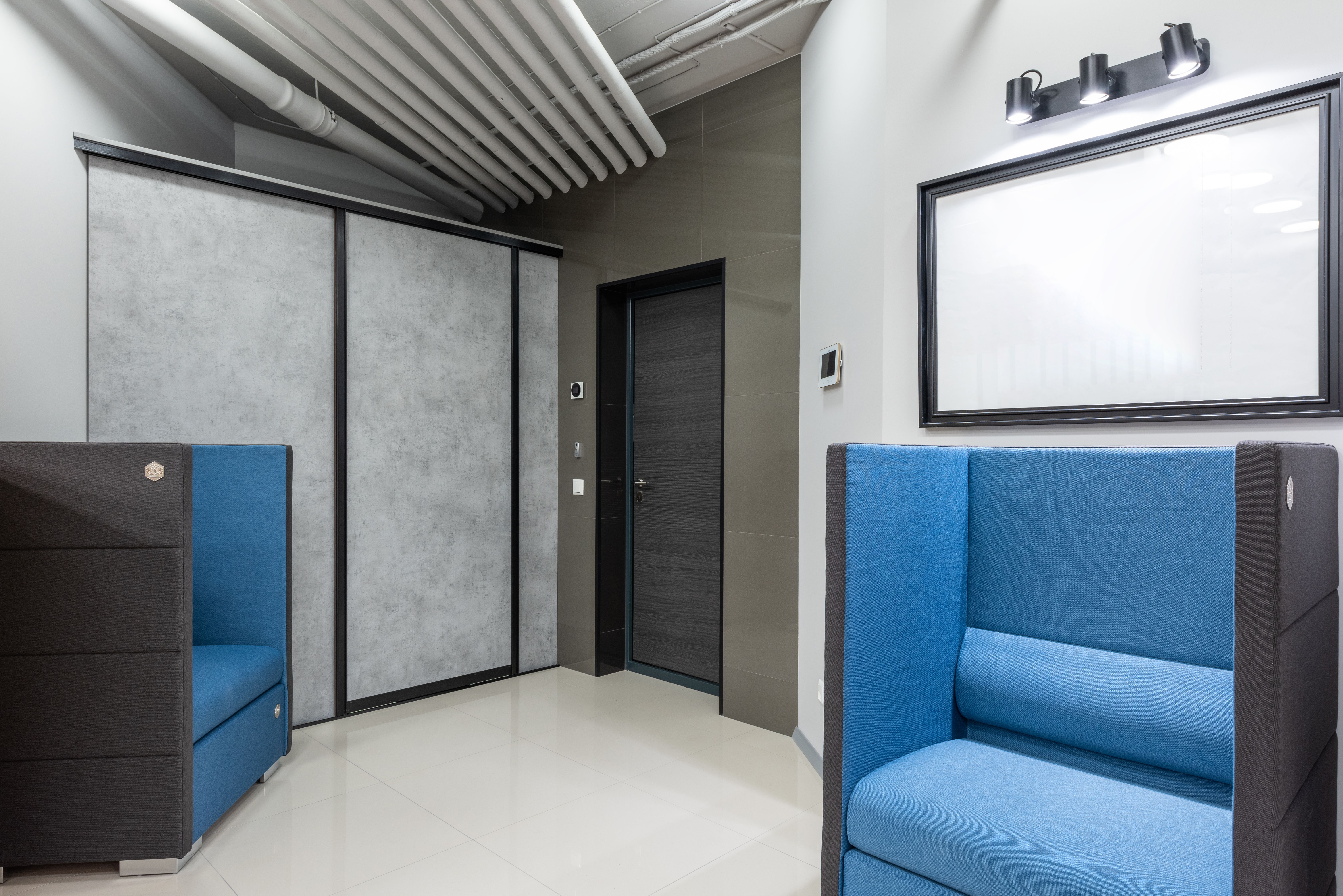 Contemporary commercial workspace with blue seating and finished flooring.